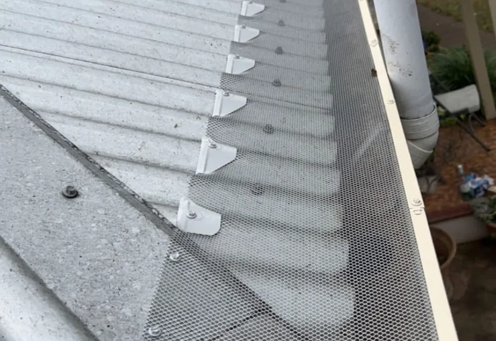 Freshly installed gutter guard mesh on a roof